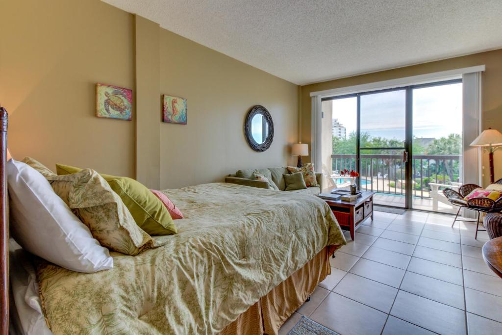a bedroom with a large bed and a balcony at Pirates Bay B206 in Fort Walton Beach