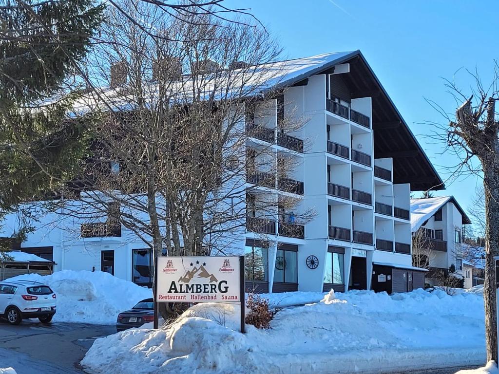 un cartel en la nieve frente a un edificio en Mitterdorf - apartmán Almberg, en Philippsreut
