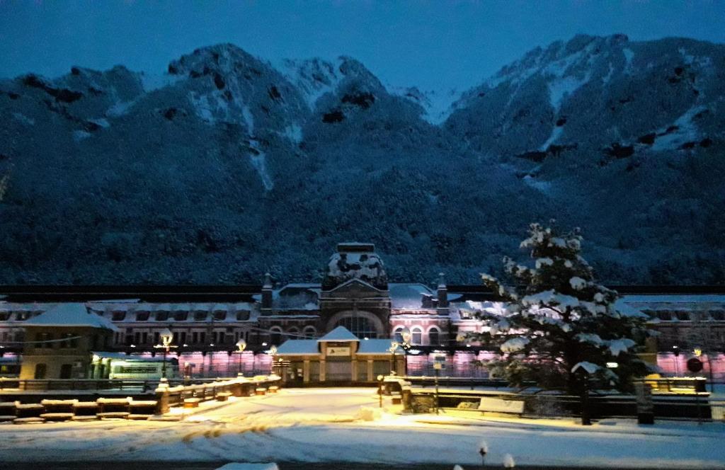 a building with a christmas tree in front of a mountain at The Family 1 in Canfranc-Estación