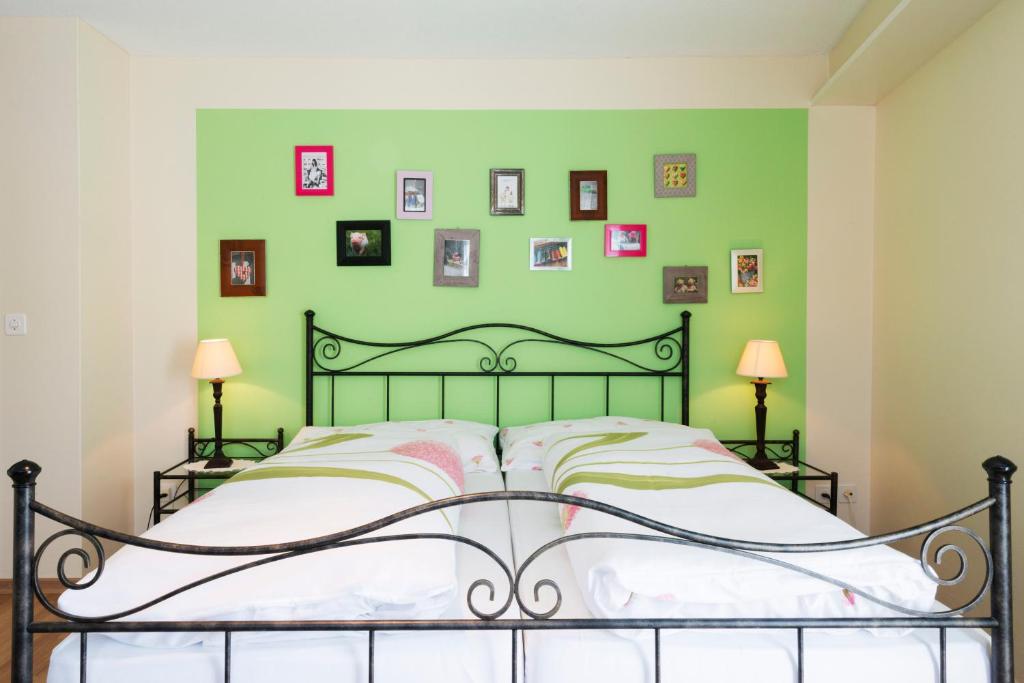 Dormitorio verde con cama y cuadros en la pared en Hotel Sternen, en Buochs