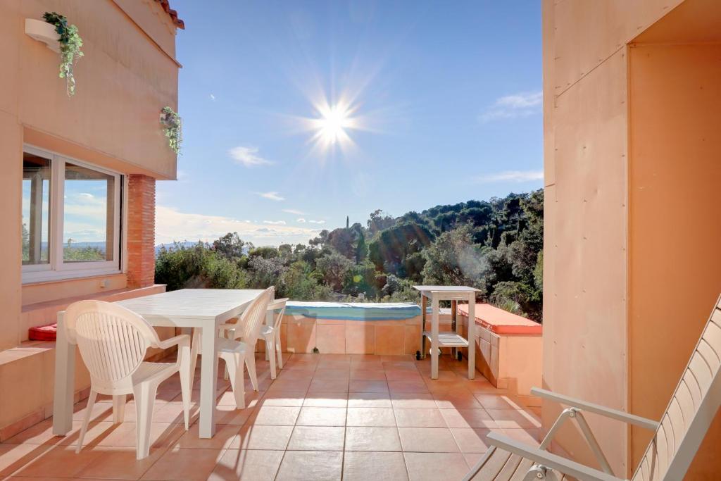 a balcony with a table and chairs and a pool at Les Iles D'Or in Rayol-Canadel-sur-Mer
