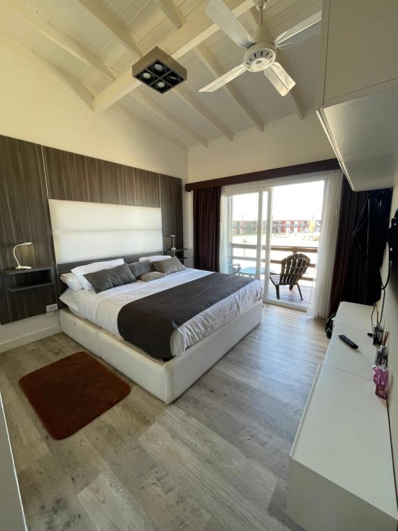 1 dormitorio con 1 cama grande y balcón en Chacras del Mar en Balneario Mar Azul