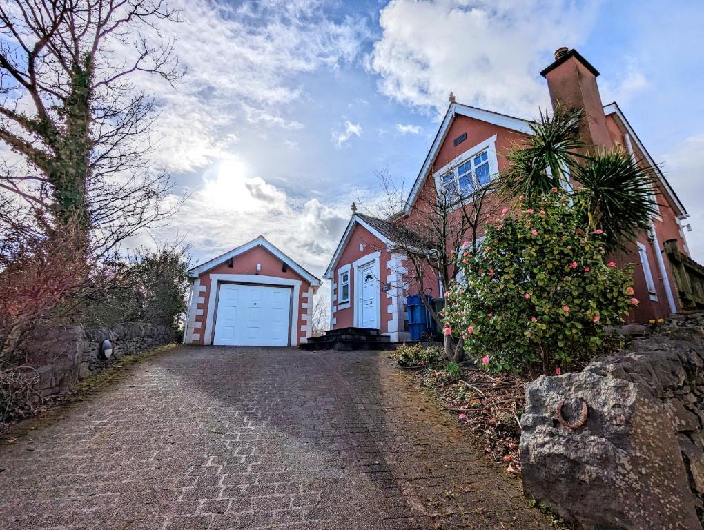 a house with a white garage and a driveway at Unbeatable Llanberis Location, Detached with Parking, Snowdon Views. in Llanberis