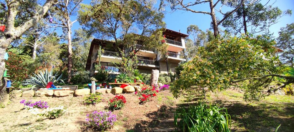 ein Haus mit einem Garten mit Blumen davor in der Unterkunft La Vista - Un lugar de Ensueño in Samaipata