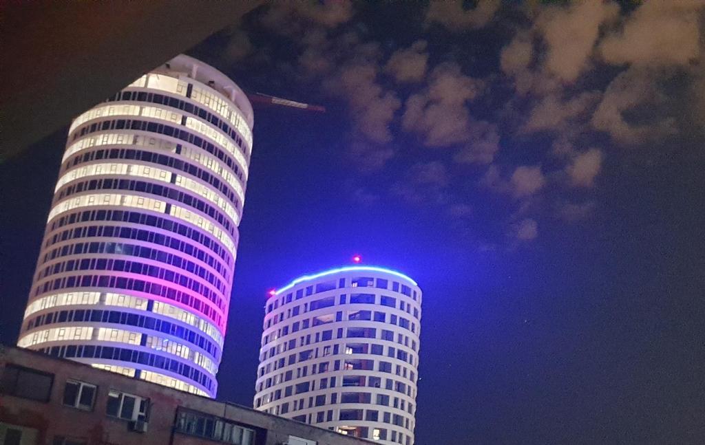 dois edifícios altos são iluminados à noite em DurmitorBW em Sajmište