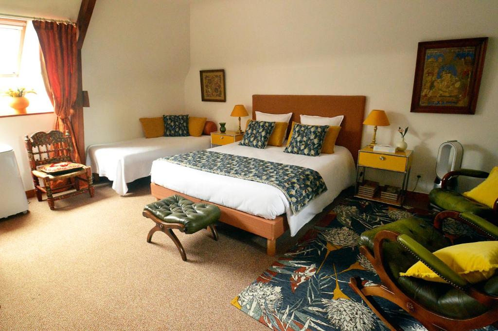 ein Hotelzimmer mit einem Bett und einem Wohnzimmer in der Unterkunft Manoir de Beaupré in Vannes