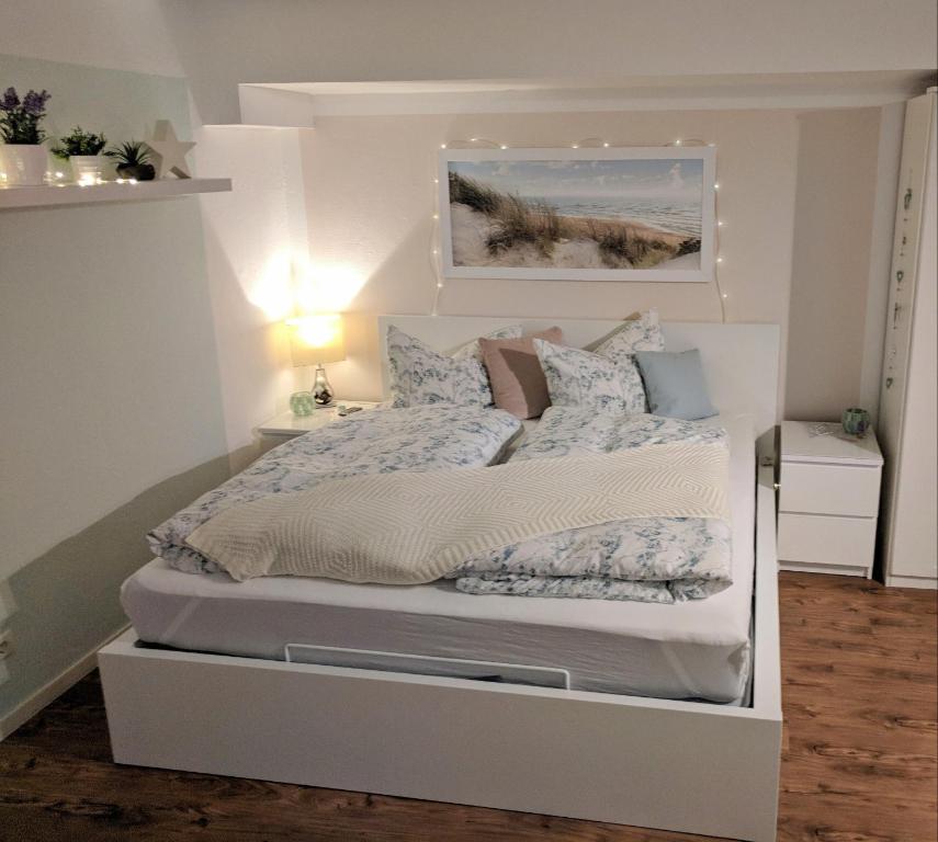 um quarto com uma cama branca com almofadas em Modernes, Mini-Apartment Nürnberg,Playmobil em Zirndorf