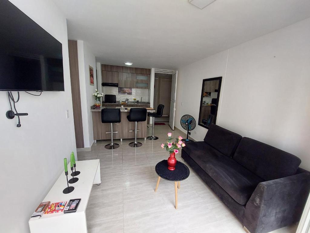 uma sala de estar com um sofá e uma mesa em Apartamento Barlovento Piso 5 Vista a la Piscina em Girardot