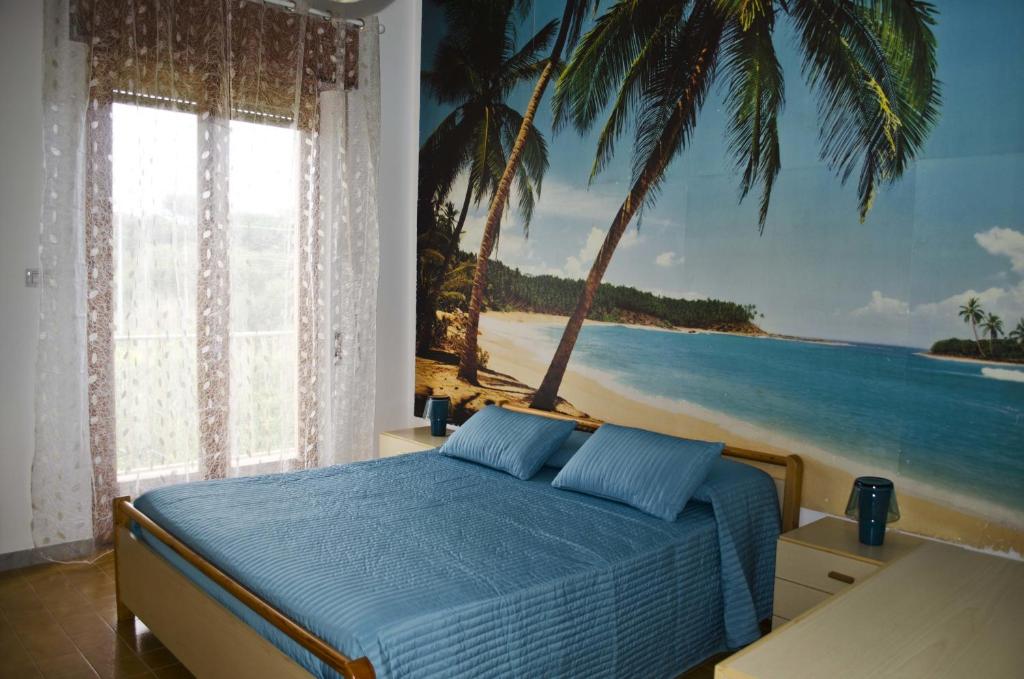 サンタ・クローチェ・カメリーナにあるVilla Cappuzzello Montalbanoのベッドルーム1室(ビーチの絵画付)