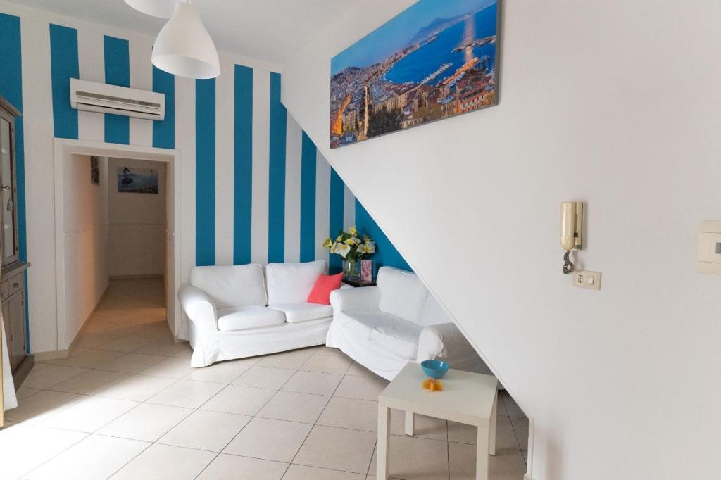 a living room with a white couch and blue and white stripes at BDREAMS APARTAMENT in Castellammare di Stabia