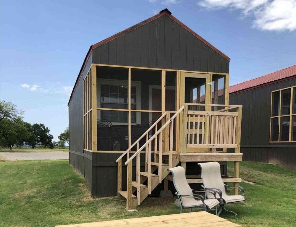 a small black house with two chairs in front of it at Lakefront Cabin - Sunset Cove - 15 in Mead