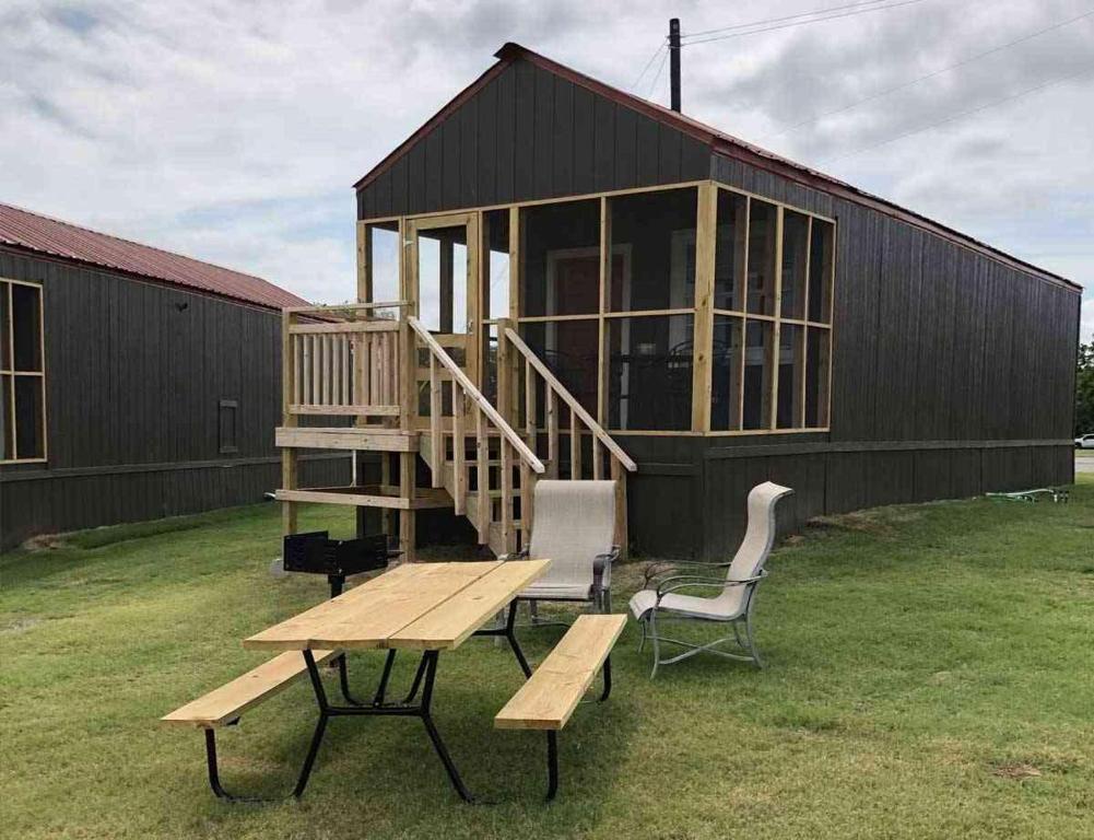 a picnic table and chairs in front of a building at Lakefront Cabin - Texoma Coast - 14 in Mead