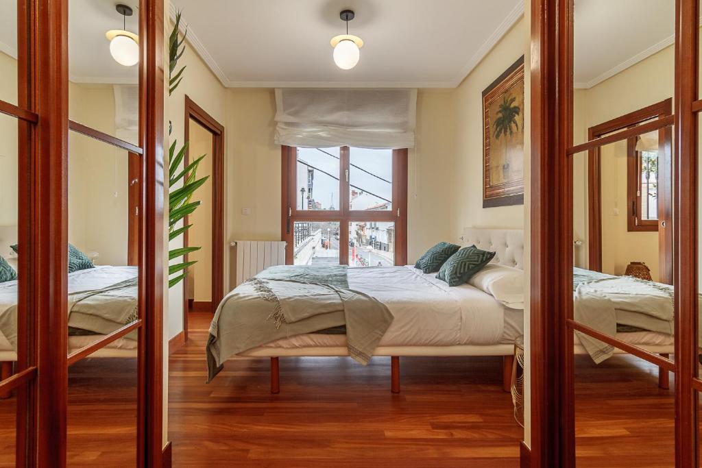 um quarto com uma cama e um espelho em Olabeaga apartamento urbano de diseño con wifi em Bilbau