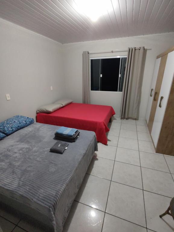 a room with two beds and a window in it at Apartamento privativo 06 in Blumenau