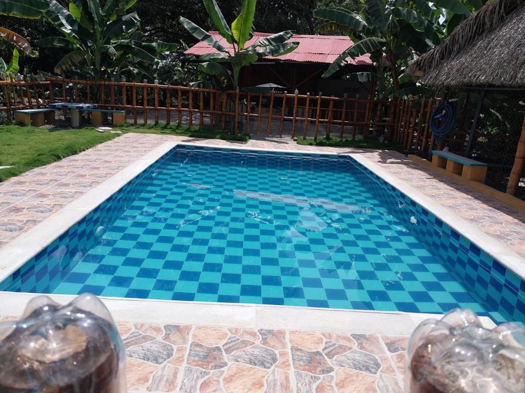 a swimming pool with blue tiles on the ground at Finca Agroturística La Sultana in El Espinal