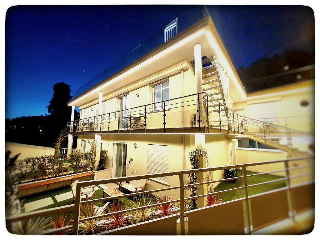 a large white house with a balcony with plants at Le Vallaya Suites & Spa in Menton