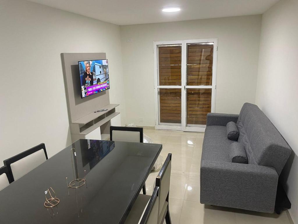 sala de estar con sofá y TV en PARQUE AGUIRRE en Santiago del Estero