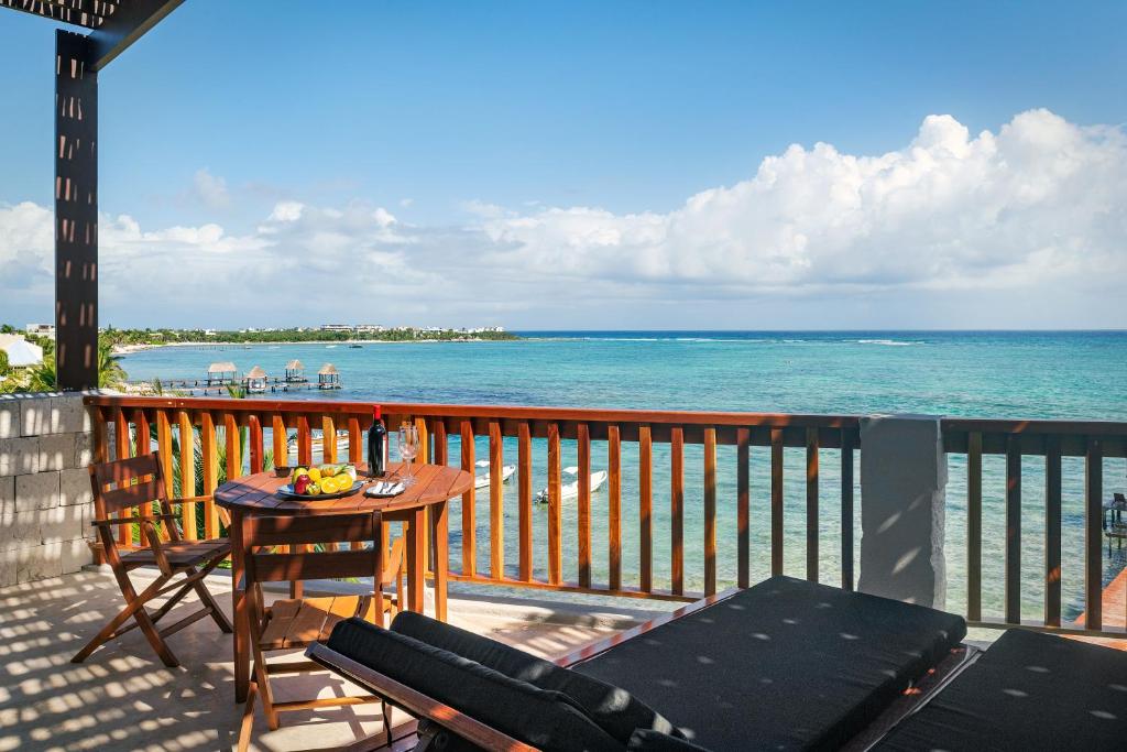 a balcony with a table and chairs and the ocean at Alea Tulum in Tulum