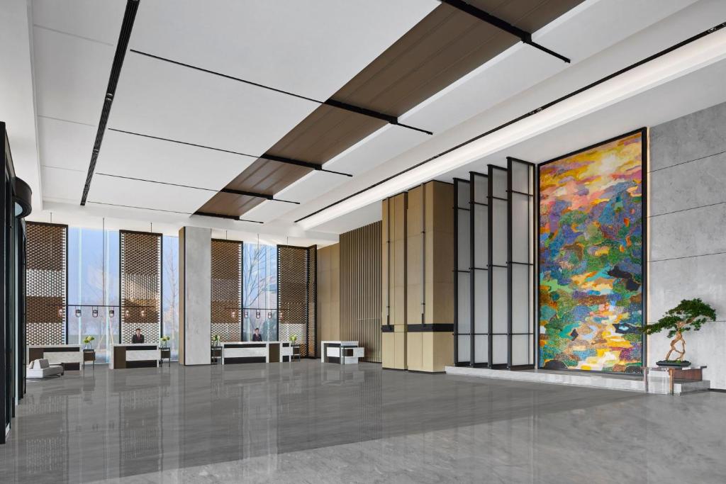 a rendering of a lobby with a large painting on the wall at Changzhou Marriott Hotel Jintan in Changzhou
