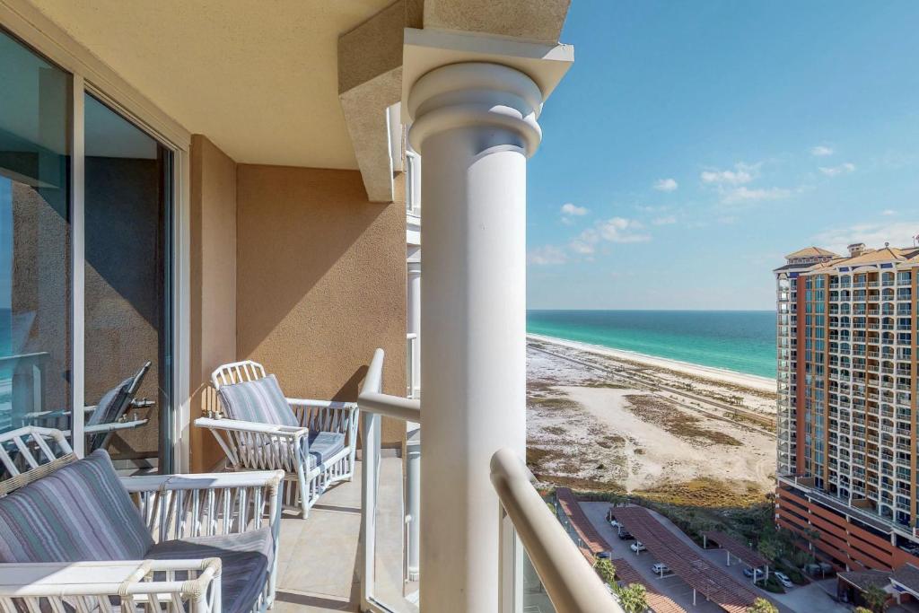 a balcony with chairs and a view of the beach at Portofino 2-1906 in Pensacola Beach
