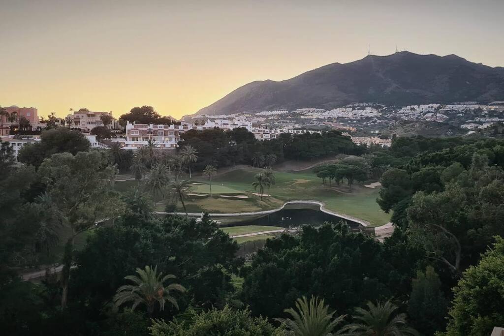 uitzicht op een golfbaan met een berg op de achtergrond bij Soleado apartamento Golf y a 900 m de la playa in Benalmádena
