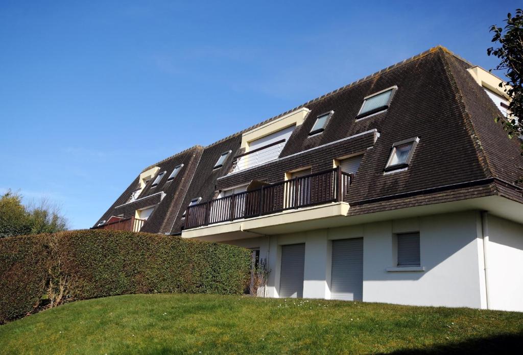 a white building with a black roof at Appart très sympa à St Aubin sur Mer in Saint-Aubin-sur-Mer