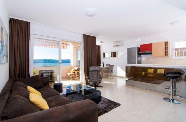 uma sala de estar com um sofá castanho e uma cozinha em Sunny place with sea view em Trogir