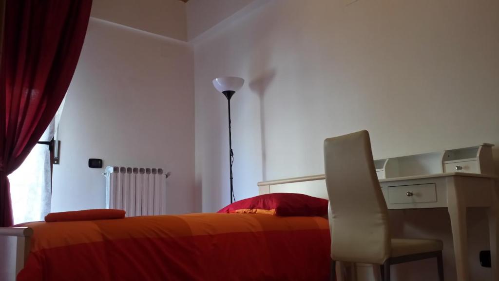 1 dormitorio con cama, escritorio y silla en Le Colonne, en Foggia