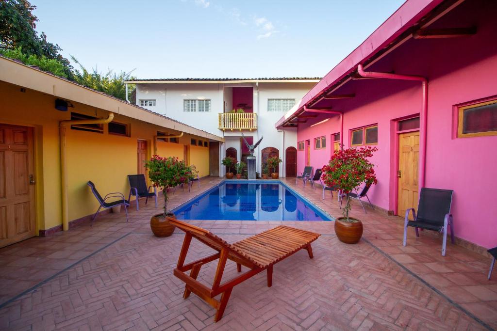 グラナダにあるHotel La Calzadaのプール、テーブル、椅子が備わる中庭