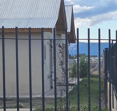 una valla frente a un edificio con una montaña en NIRELLE CALAFATE SUITES en El Calafate