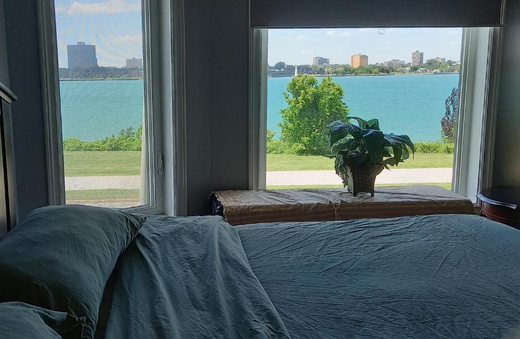 a bedroom with a large window with a potted plant at WaterfrontHome-RiverView, Windsor ,Canada in Windsor