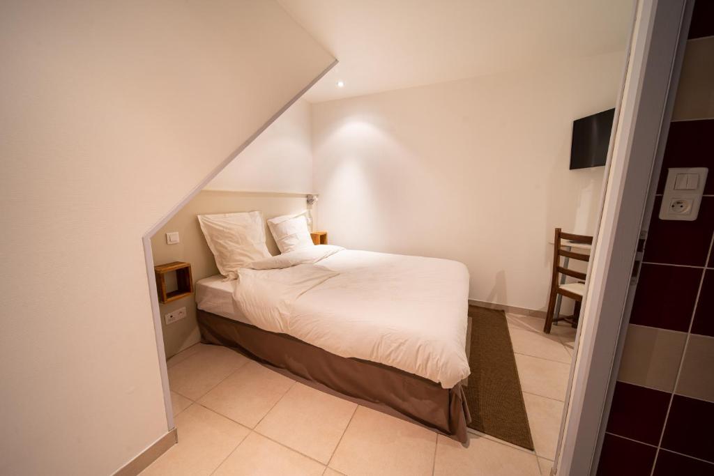 niewielka sypialnia z łóżkiem z białą pościelą w obiekcie Appartement haut de gamme Centre ville w mieście Chalon-sur-Saône