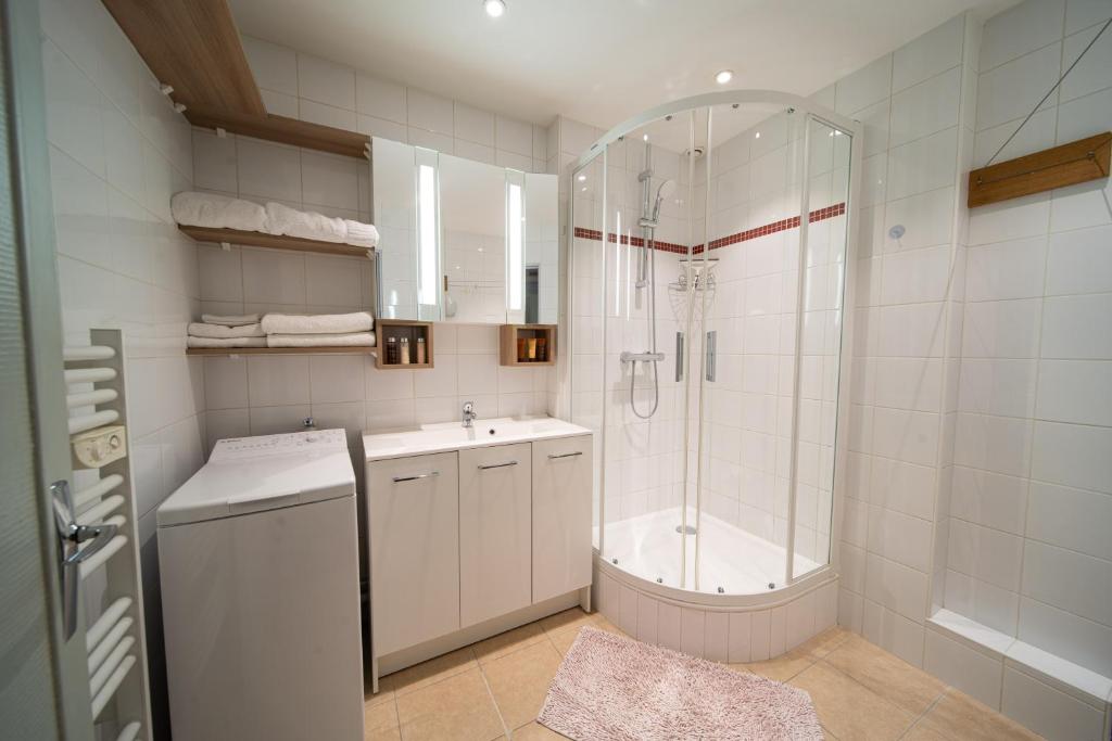biała łazienka z prysznicem i umywalką w obiekcie Appartement haut de gamme Centre ville w mieście Chalon-sur-Saône