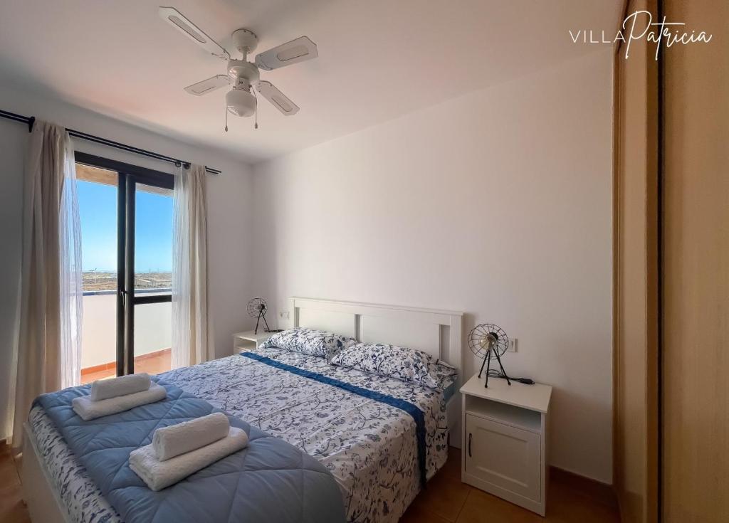 une chambre avec un lit et un ventilateur de plafond dans l'établissement Villa Patricia, à Corralejo
