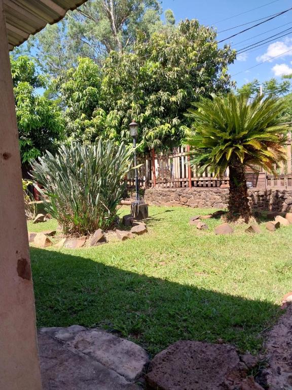 vistas a un patio con árboles y césped en Alojamiento UMA en Puerto Iguazú