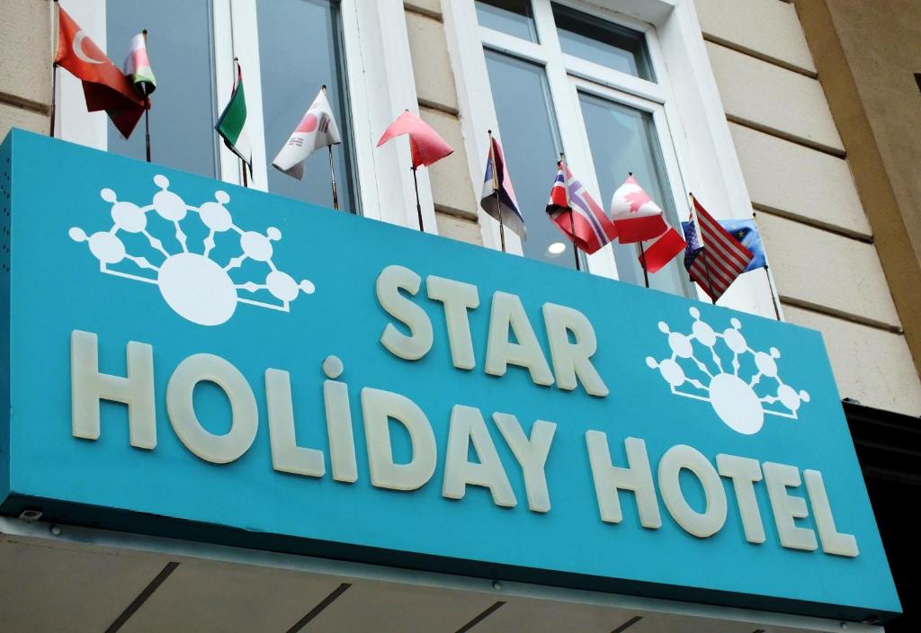 un cartel para un hotel de vacaciones estrella frente a banderas en Star Holiday Hotel en Estambul