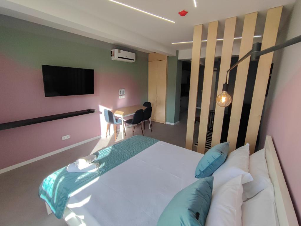 a bedroom with a bed and a television and a table at Social Lodge - Happiness in Funchal