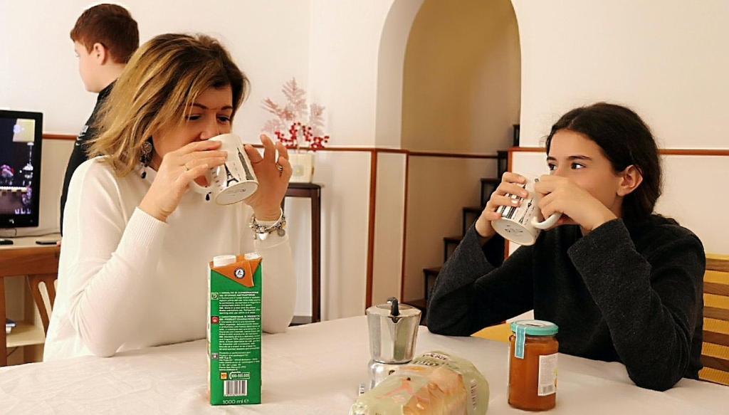 dwie kobiety siedzące przy stole pijące kawę w obiekcie Casa Mafalda w mieście Aradeo