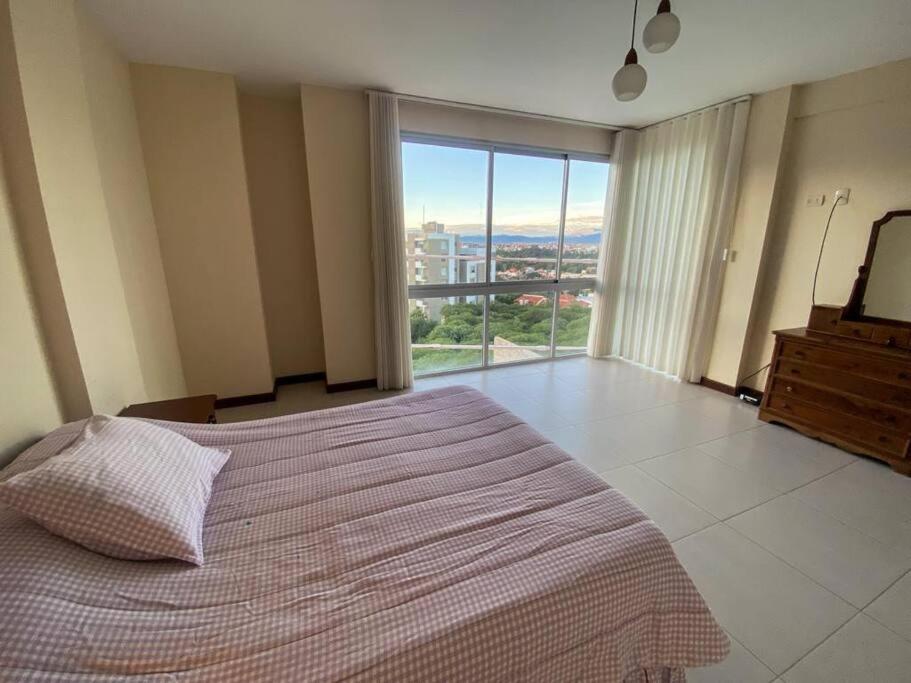 1 dormitorio con cama grande y ventana grande en Hermoso departamento de lujo - Zona Miraflores, en Tarija