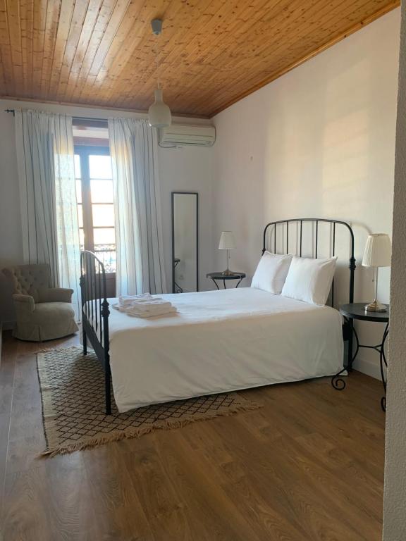 a bedroom with a large bed with white sheets at Casa do Rossio in Estremoz