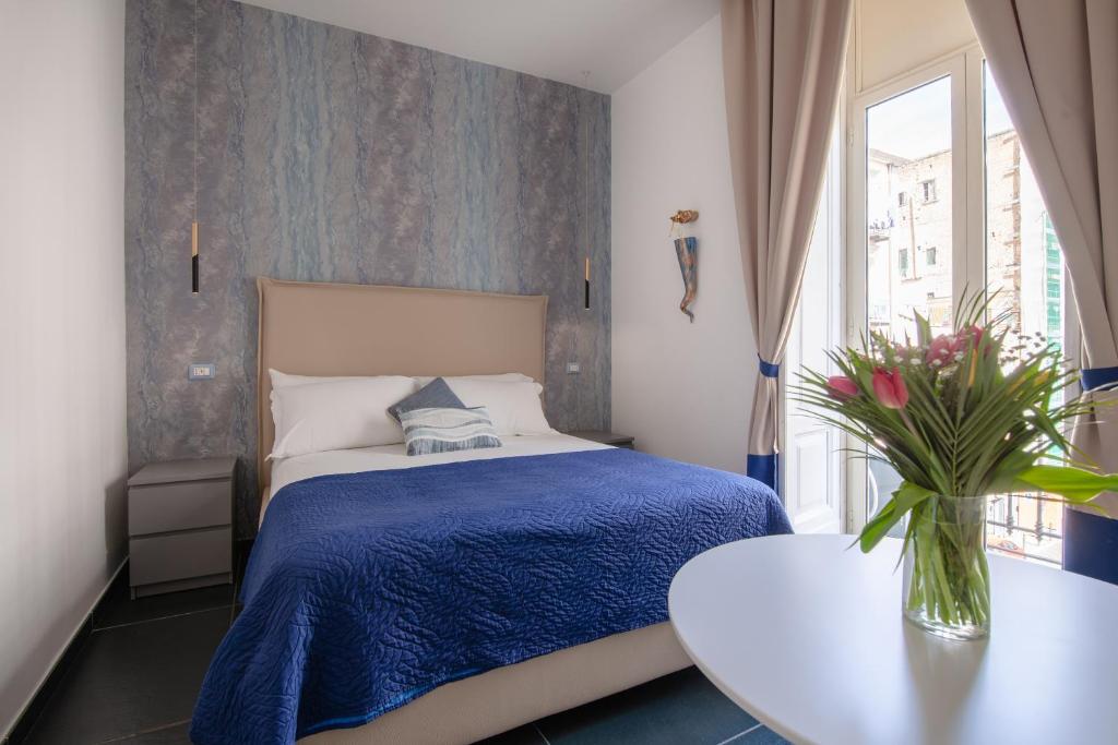 Un dormitorio con una cama y una mesa y una ventana. en I Canestrari, en Nápoles