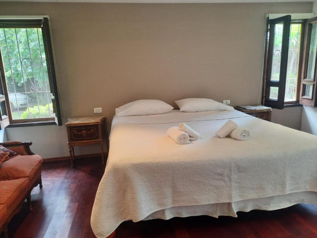 1 dormitorio con 1 cama con toallas en HABITACION CON PISCINA Y PARQUE en Chacras de Coria en Chacras de Coria