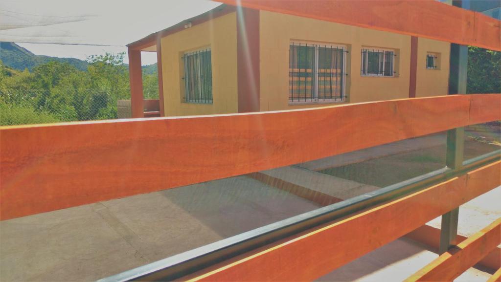 un primer plano de un banco de madera frente a un edificio en Departamento C/Cochera. Ubicación inmejorable. Sobre Av. Principal. en Potrero de los Funes
