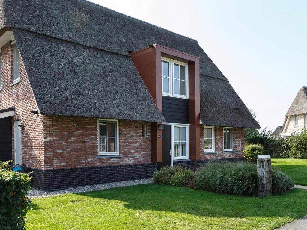 una casa con techo de tejas en Luxury villa with gas fireplace, on a holiday park on the Tjeukemeer, en Delfstrahuizen