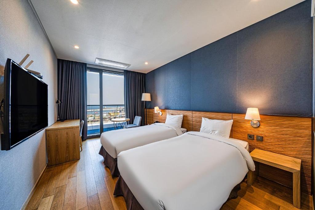 Postel nebo postele na pokoji v ubytování SL Hotel Gangneung