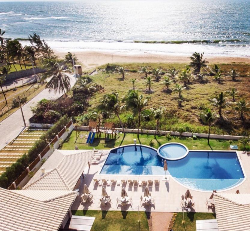 an aerial view of a resort with a pool and the beach at Village Pé na Areia - Itacimirim in Itacimirim