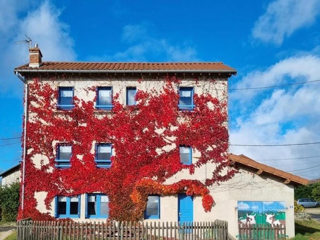 um edifício com folhas vermelhas na lateral em Gîte Saint-Pierre-du-Champ, 5 pièces, 8 personnes - FR-1-582-61 em Saint-Pierre-Duchamp