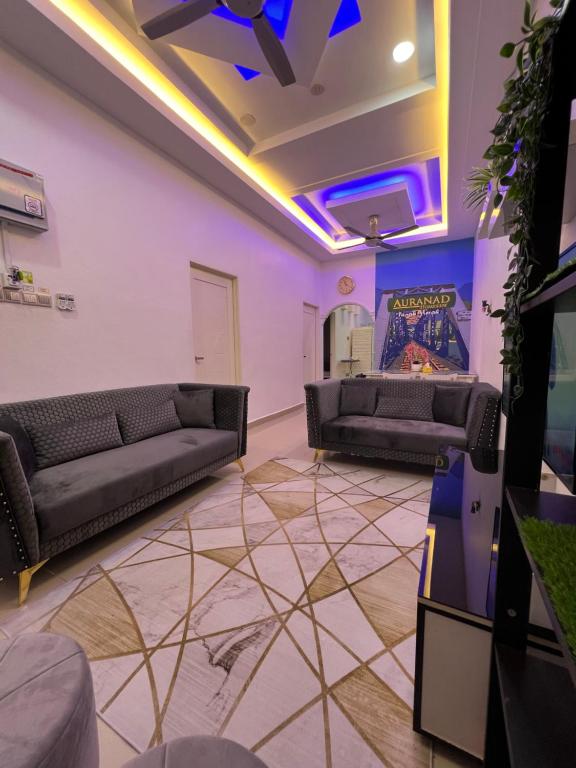Auranad Guest House Tanah Merah Wifi-Netflix في Kampong Tanah Merah: غرفة معيشة مع كنبتين وتلفزيون