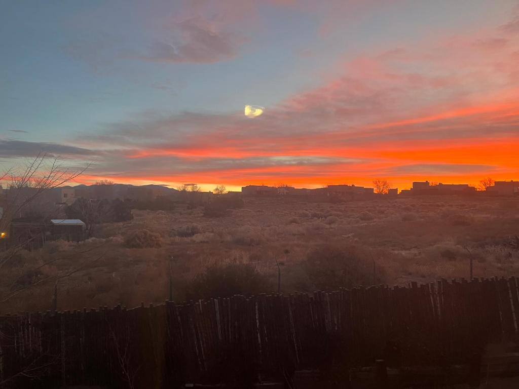 um pôr-do-sol sobre uma cidade com uma cerca em Santa Fe Charm Home em Santa Fé