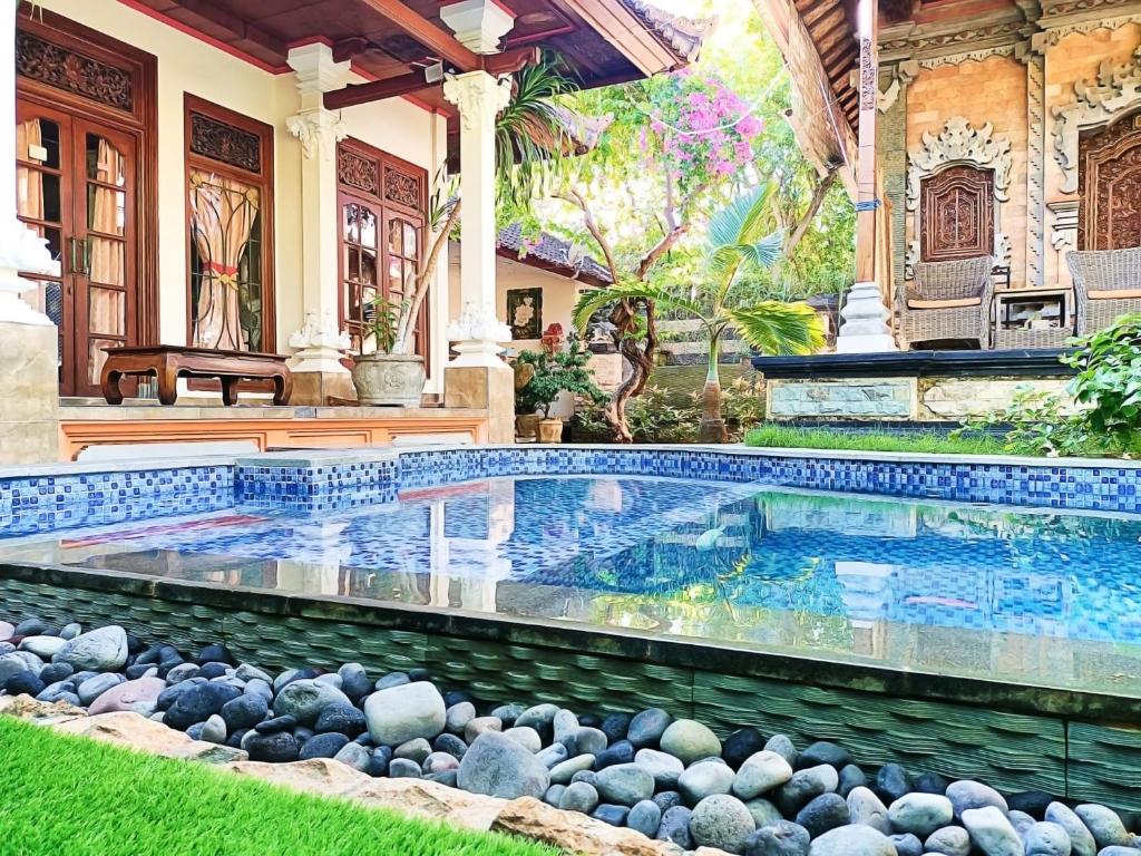 a swimming pool in the yard of a house at Green Palace Homestay in Nusa Penida